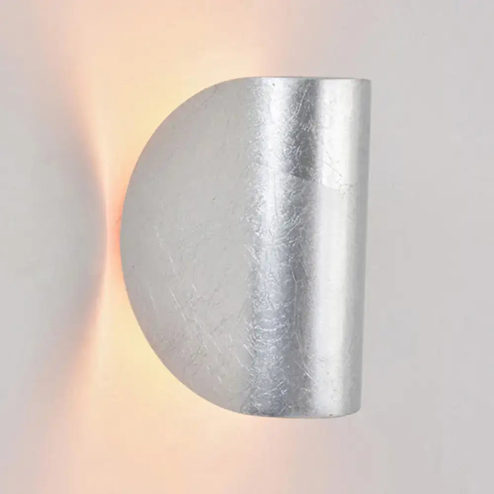 Modern curved gold wall sconce light with brushed metallic finish and subtle texture for bedroom ambient lighting