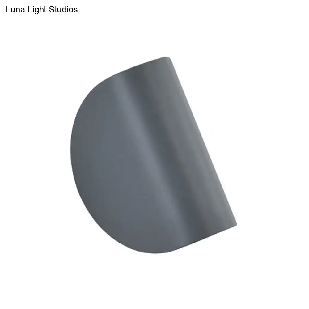 A sleek matte grey semi-circular wall sconce light with a modern design for bedroom ambient lighting