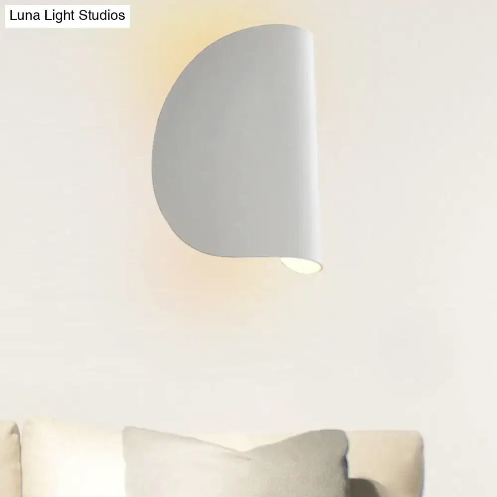 A sleek minimalist white wall sconce light with a curved half-circular design for bedroom ambient lighting