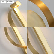 Modern curved gold wall sconce with sleek metallic bands and warm white light for bedroom lighting fixture