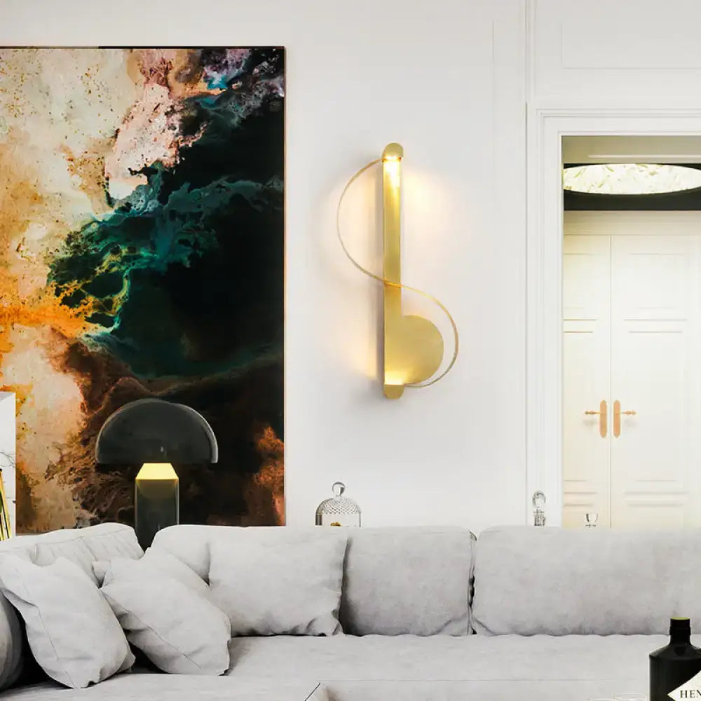 Modern curved gold wall sconce with sleek design and warm white light for ambient bedroom lighting