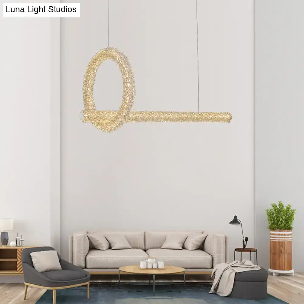 A modern gold-toned key-shaped cut crystal ceiling light pendant with textured surface for 220v-240v kitchen island