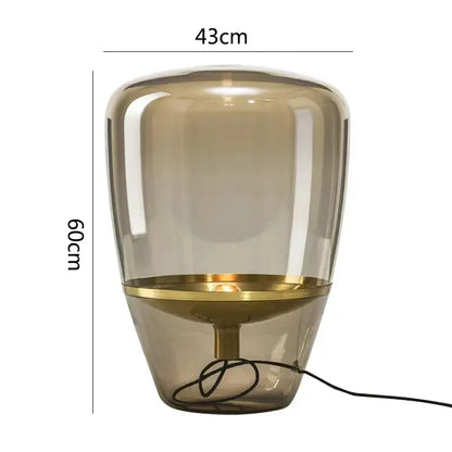 A sleek 60cm tall decorbites glass table lamp with translucent amber glass body and polished brass ring for bedroom lighting