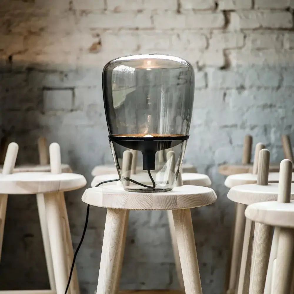A sleek modern decorbites glass table lamp with a transparent body and black base for bedroom led lighting