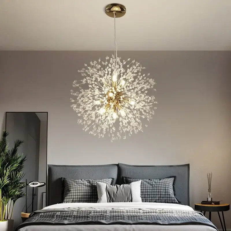A sparkling gold-toned decorbites dandelion crystal chandelier with crystal-like branches and multiple bulbs above a bed