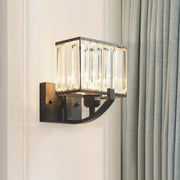 A modern dark bronze wall mount light with vertical crystal rods in a rectangular frame for bedroom use