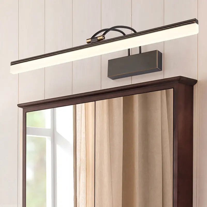 Modern dark bronze led wall light with brass accents and adjustable color temperature mounted above a wooden mirror