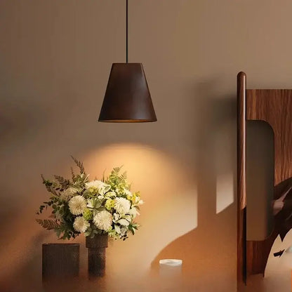 Dark brown conical pendant light with matte finish hanging from black cord in decorbites adjustable wooden chandelier