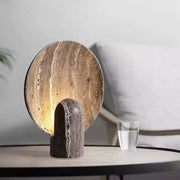 A sleek modern dark travertine rock led table lamp with a warm glow suitable for bedroom use