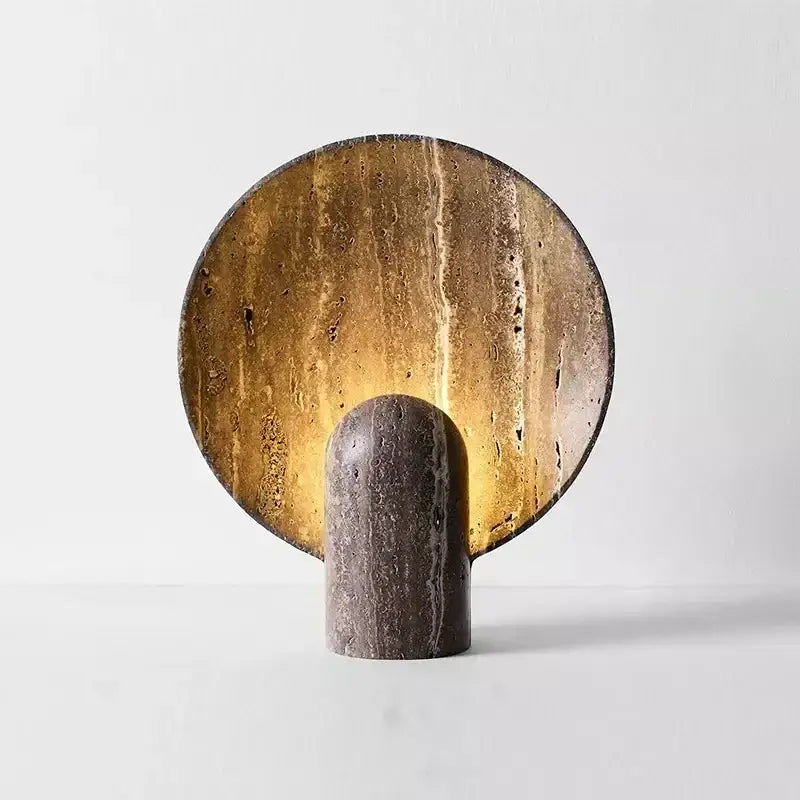 A modern dark travertine rock led table lamp with a warm golden glow and textured stone base for bedroom use