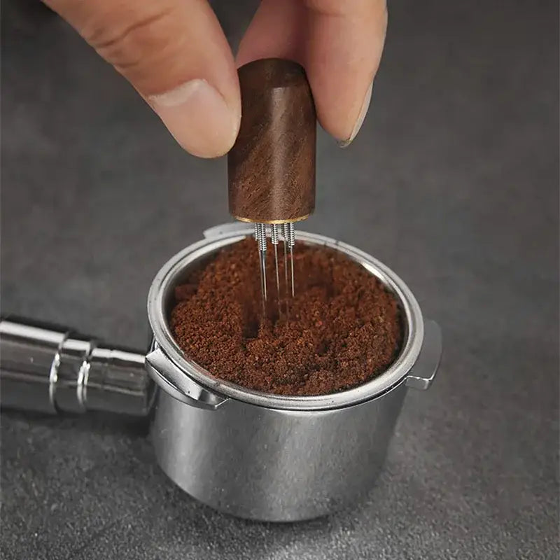 Modern dark wood espresso coffee stirrer with metallic needle distributor base for evenly compressing ground coffee