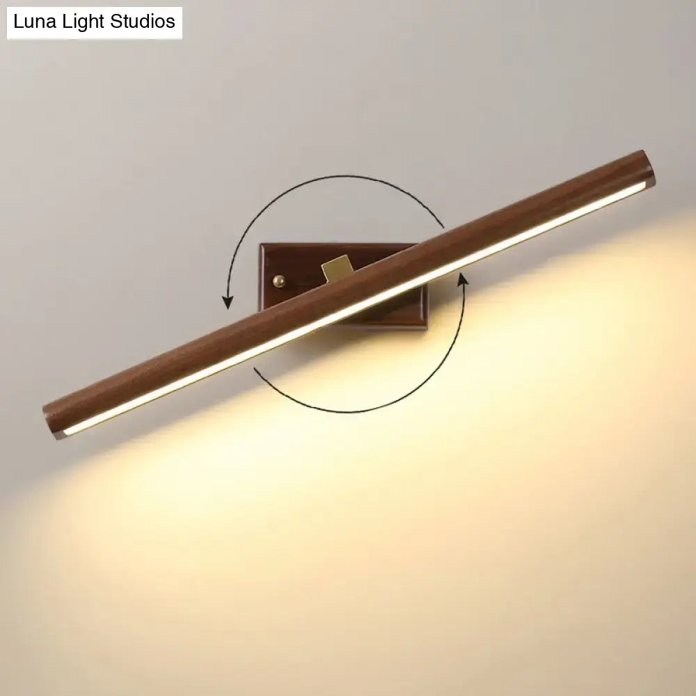 Modern dark wood linear wall sconce with warm-toned wooden finish and adjustable angle for bathroom vanity lighting