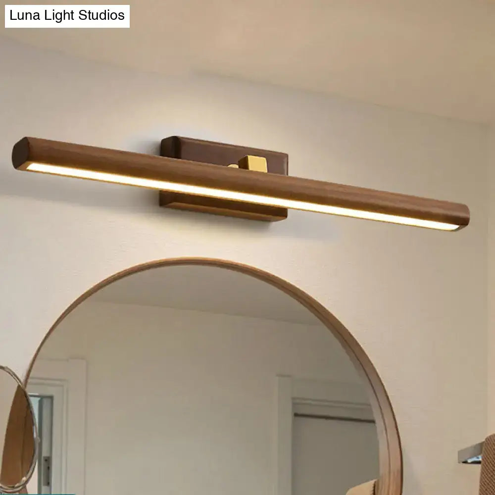 Modern dark wood linear wall sconce bathroom vanity light with warm-toned wood and brass accents in a sleek design
