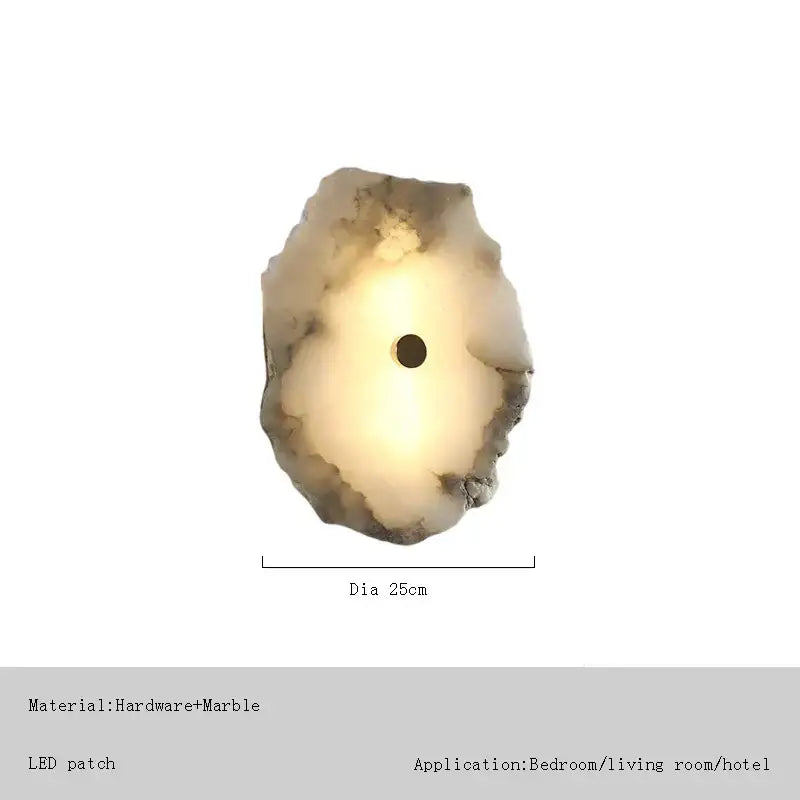 A warm circular led-lit decorbites brass marble wall sconce with irregular surface in earthy tones for modern lighting