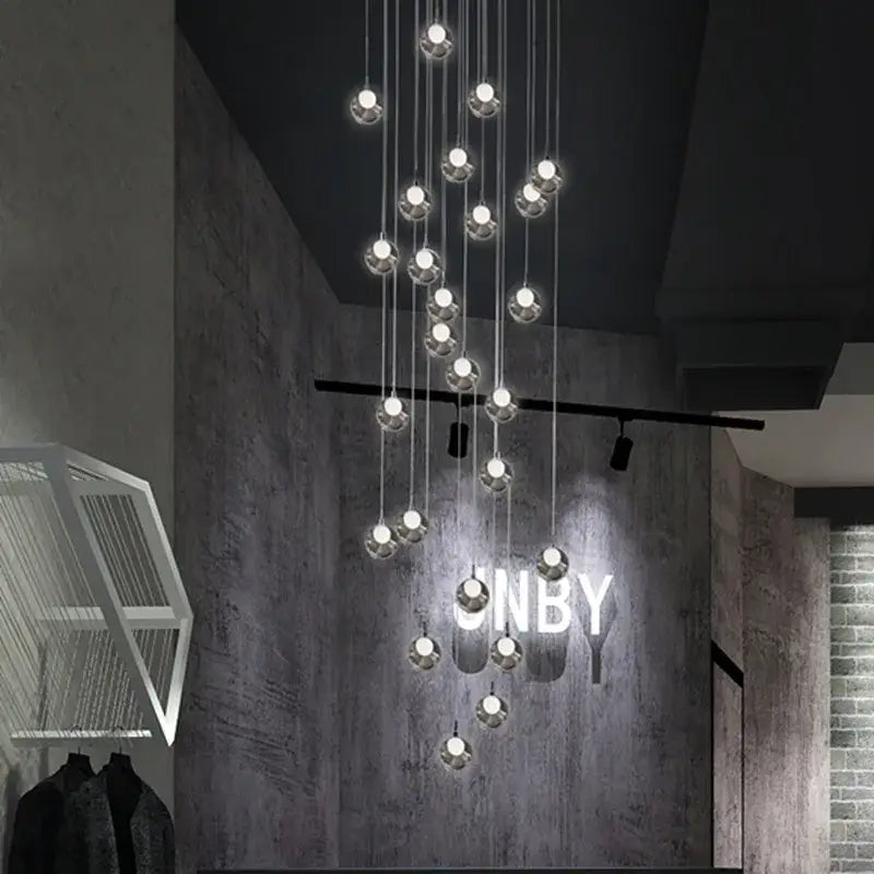 Modern decorbites bubble led chandelier with chrome-finished spherical glass pendants illuminating a dark dining room wall