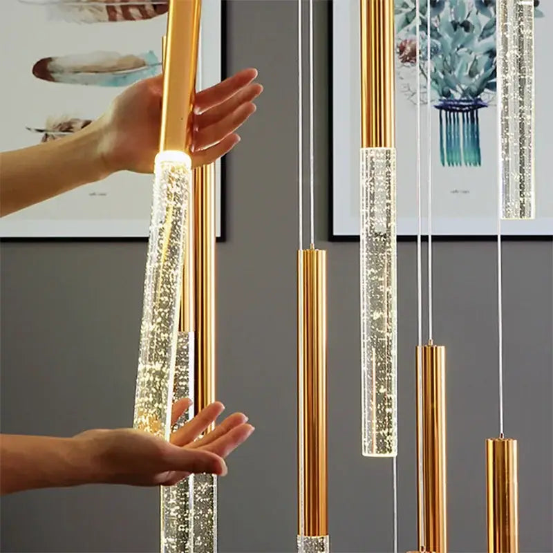 Modern decorbites crystal gold chandelier with gold-toned cylindrical pendant lights and warm led illumination
