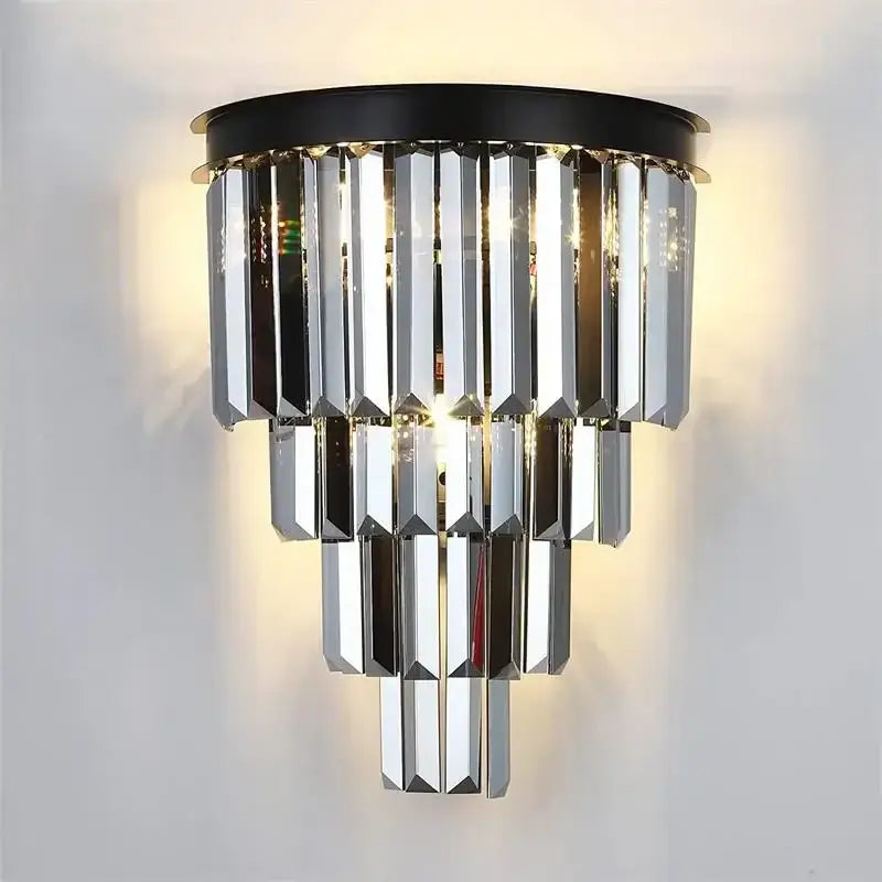 A modern decorbites crystal gold multi-tiered chandelier with cascading crystal prisms on a black circular base
