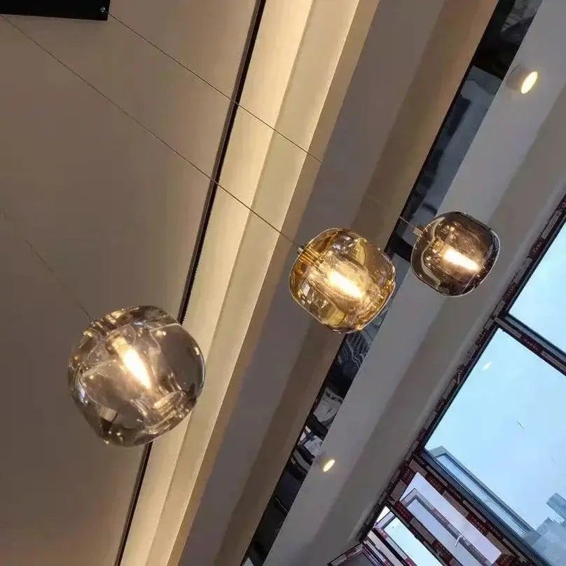 Three spherical decorbites crystal led pendant lights with warm golden glow in living room modern chandelier orb design