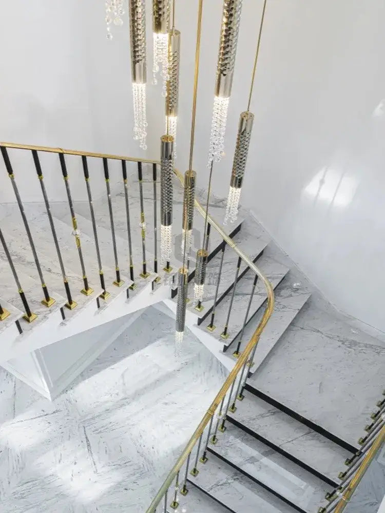Gold-toned decorbites crystal led large staircase chandelier with cascading crystal pendants and textured metallic rods