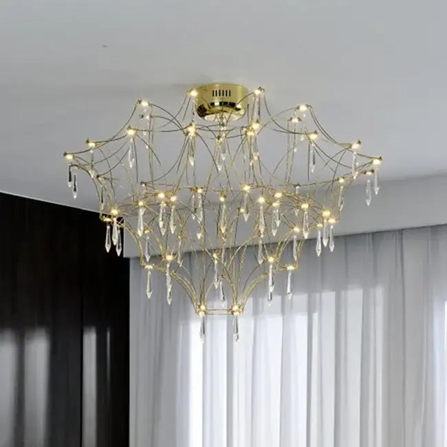 A golden chrome living room chandelier with intricate branching arms and dangling crystals from decorbites deluxe crystal