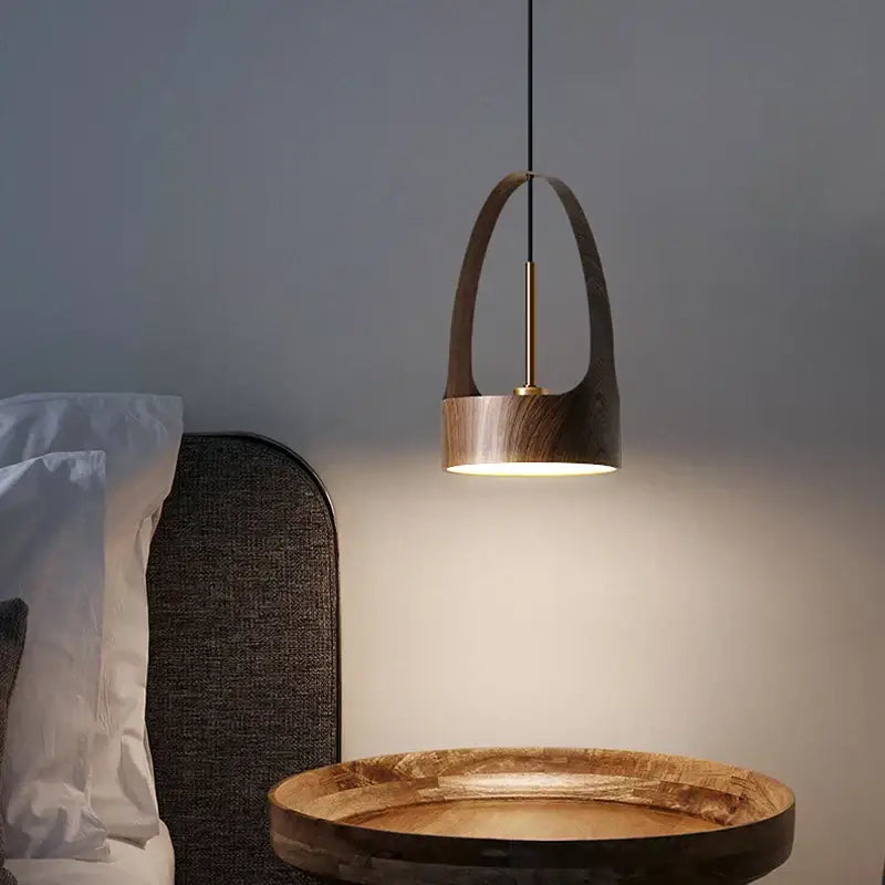 Modern decorbites led wood grain chandelier with dark wood arched frame and brass accents above wooden table