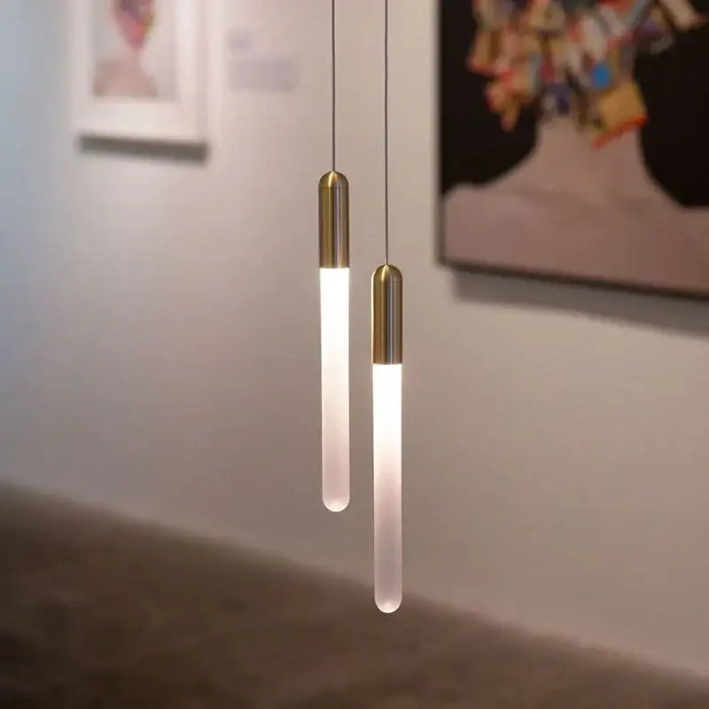 Two modern decorbites luxe gold pendant lights with frosted glass and brass caps for dining room lighting