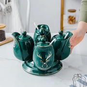 Modern deep green ceramic seasoning set with rotatable spice jars featuring gold deer motifs and white spoons