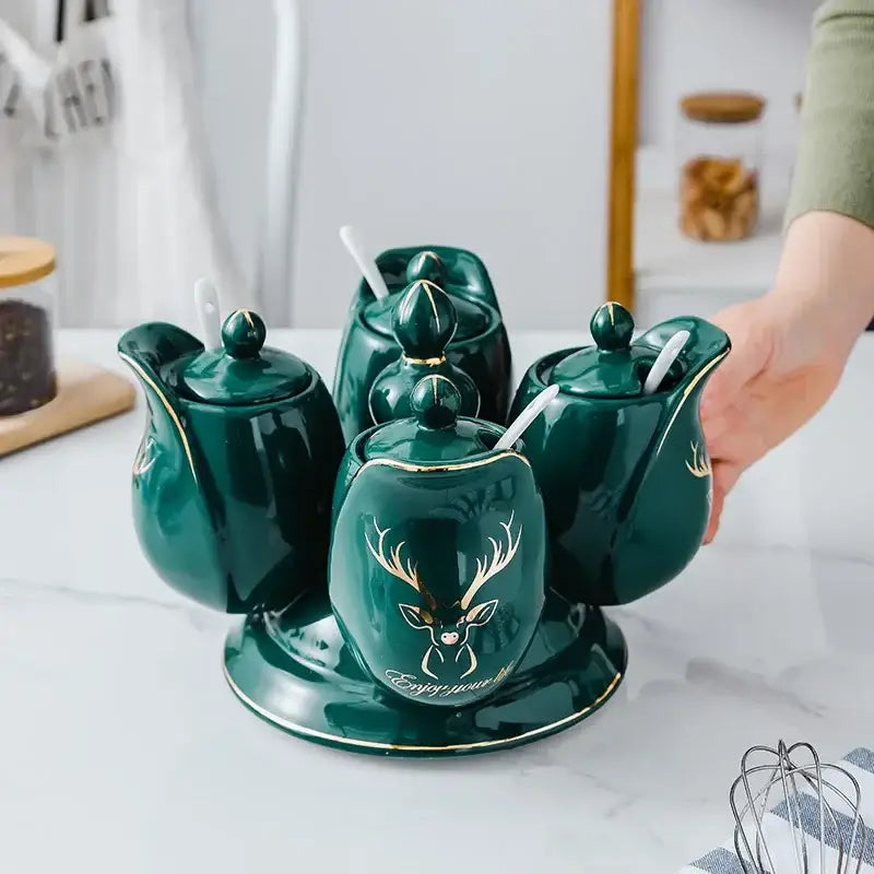 Modern deep green ceramic seasoning set with rotatable spice jars featuring gold deer motifs and white spoons