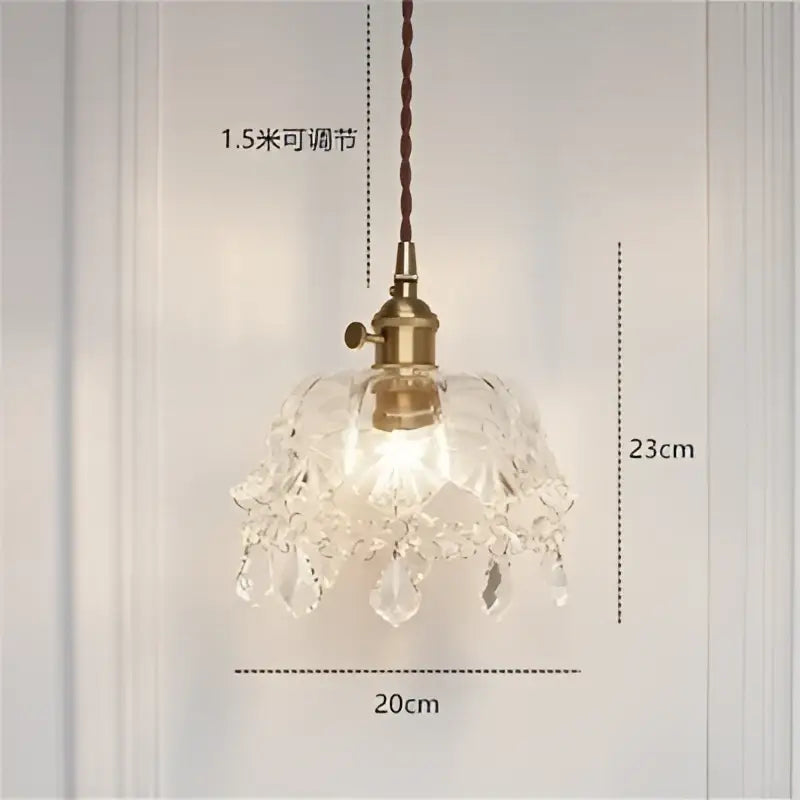 A modern pendant light with diamond amber glass and brass-finished fixture featuring teardrop crystals for dining room