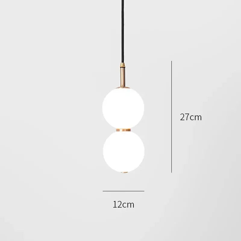 Modern pendant light with two frosted glass spheres and brass accents suspended by a black cord double balls glass chandelier