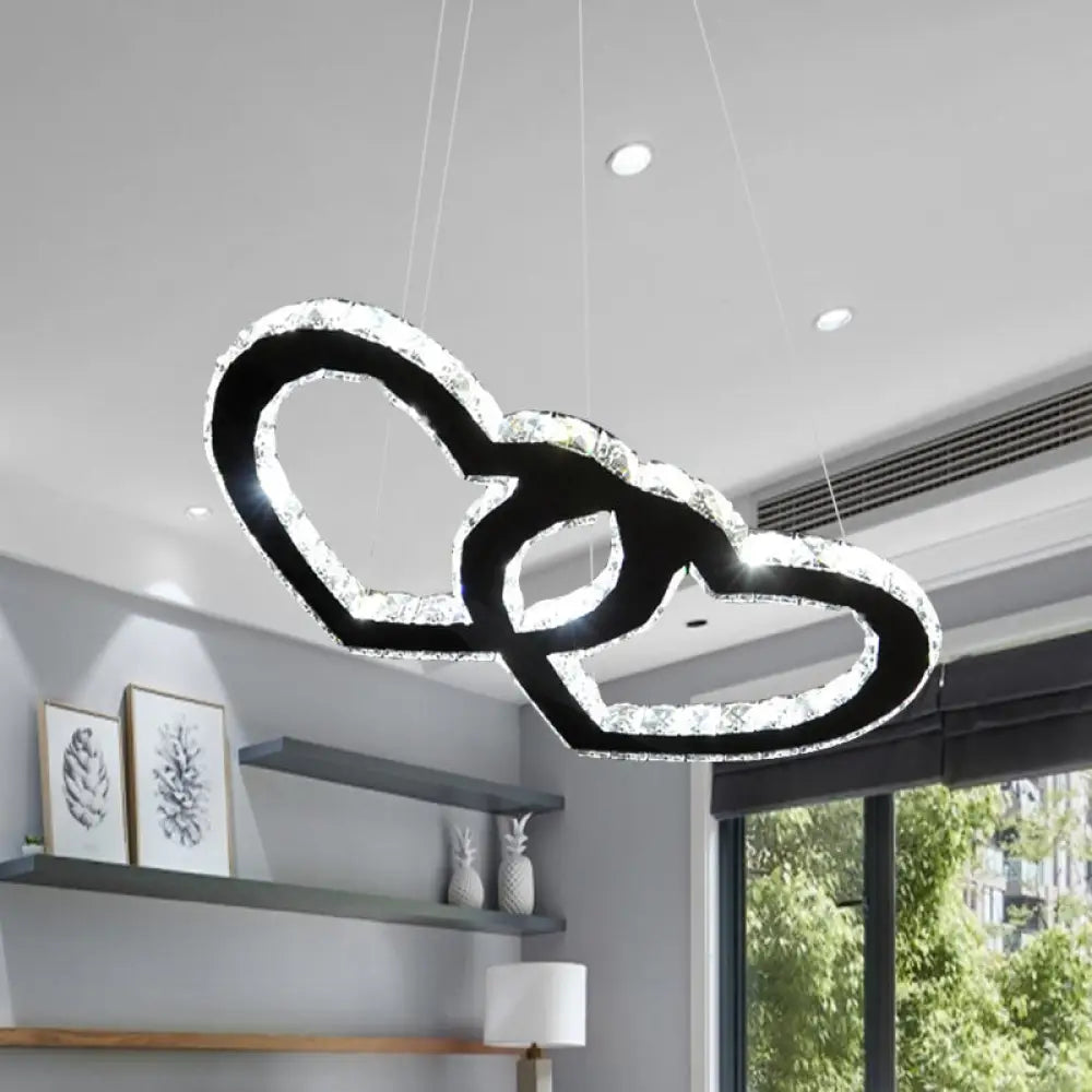 Lámpara de araña colgante LED moderna con forma de doble corazón, cristal transparente, pantalla negra y luz cálida/blanca.