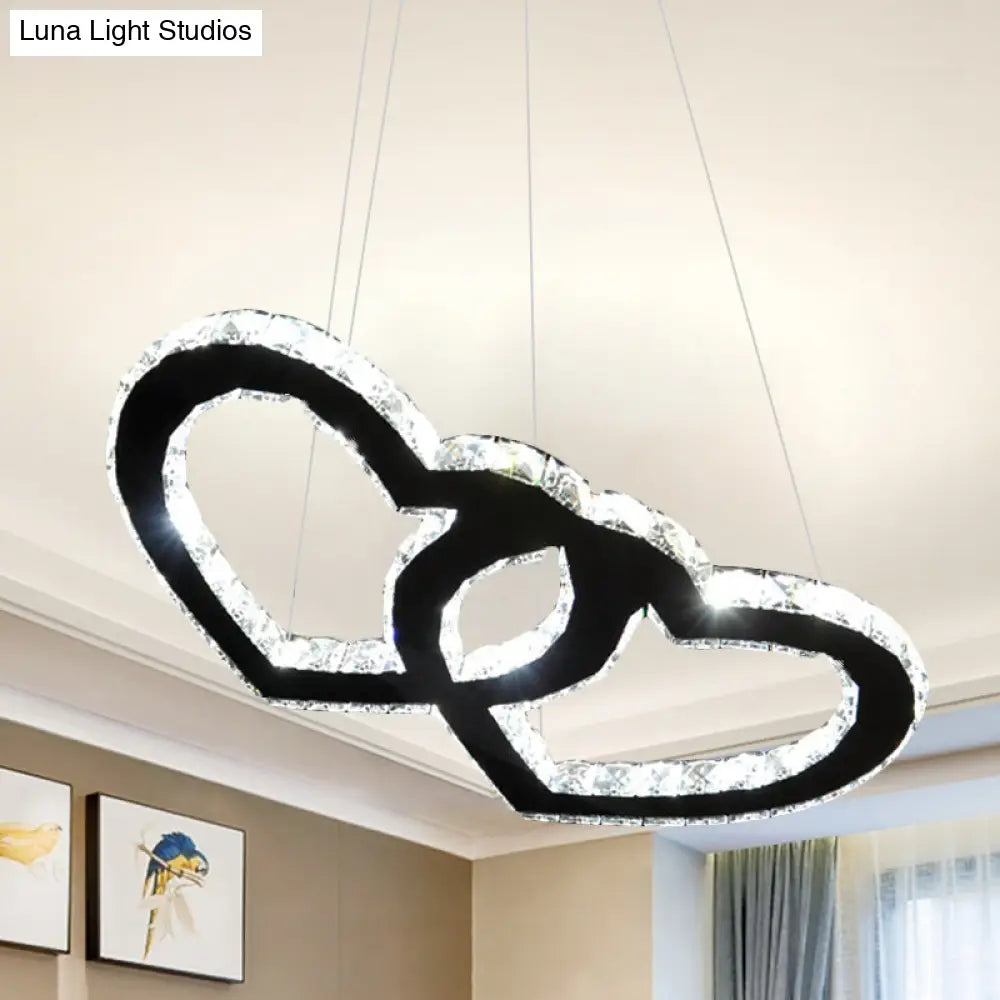 Lámpara de araña colgante LED moderna con forma de doble corazón, cristal transparente, pantalla negra y luz cálida/blanca.
