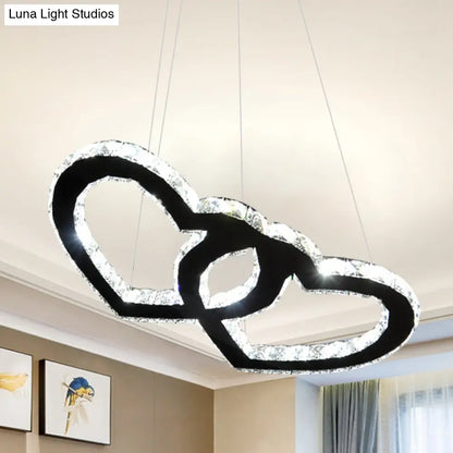 Lámpara de araña colgante LED moderna con forma de doble corazón, cristal transparente, pantalla negra y luz cálida/blanca.