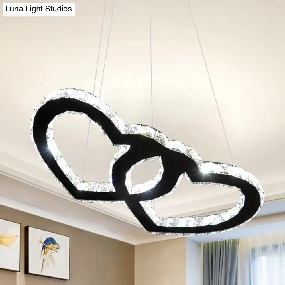 Lámpara de araña colgante LED moderna con forma de doble corazón, cristal transparente, pantalla negra y luz cálida/blanca.