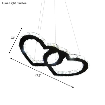 Lámpara de araña colgante LED moderna con forma de doble corazón, cristal transparente, pantalla negra y luz cálida/blanca.