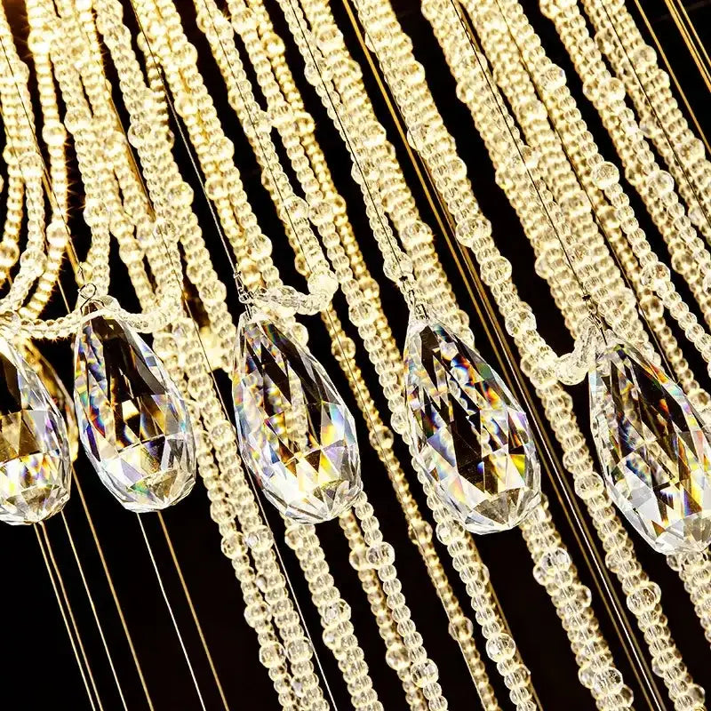 Modern double spiral staircase crystal ceiling chandelier featuring gold-toned chains with teardrop pendants and clear glass beads