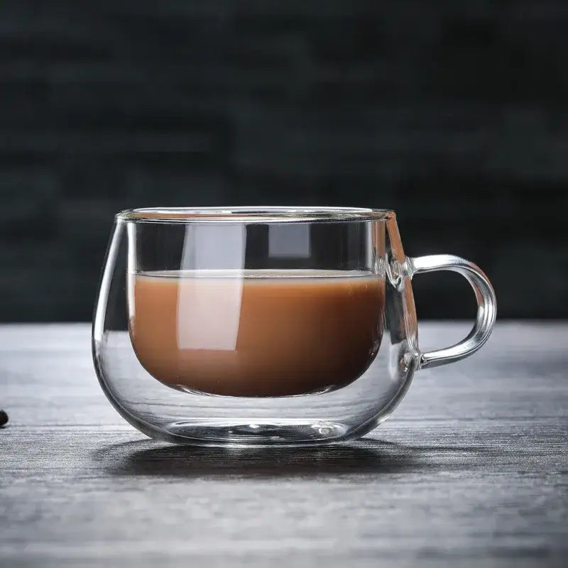 Clear double wall glass coffee cup with handle filled with brown liquid ideal for modern espresso use