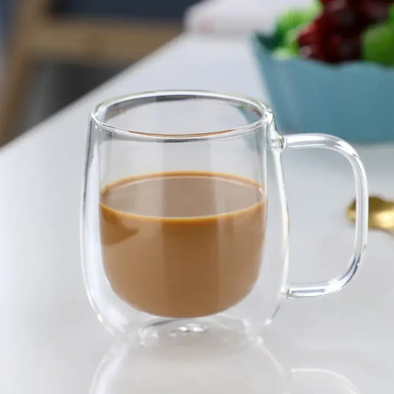 Clear double wall glass coffee cup with handle filled with brown liquid modern espresso mug
