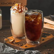 Two modern double wall glass coffee mugs one with iced coffee and one with caramel milkshake topped with whipped cream