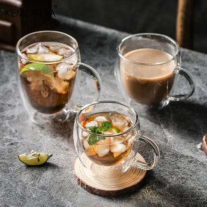 Modern double walled transparent glass cups filled with iced beverages garnished with lime and mint leaves