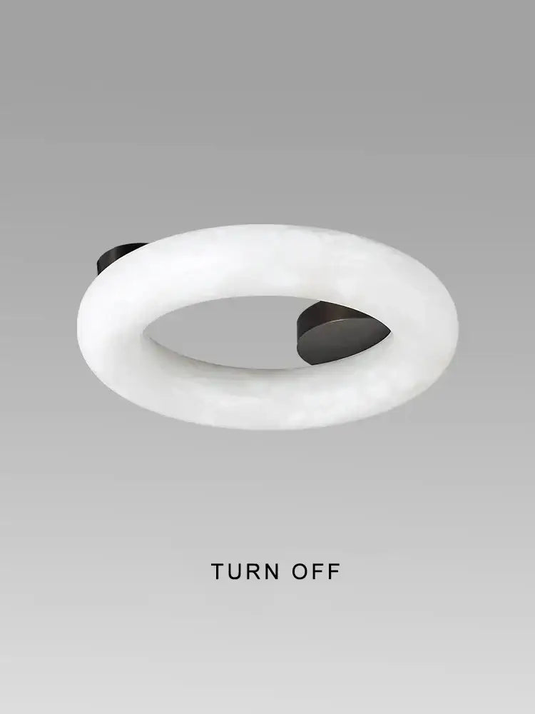 A sleek white ring light with black mounts for modern elegant alabaster marble ceiling chandelier in living room