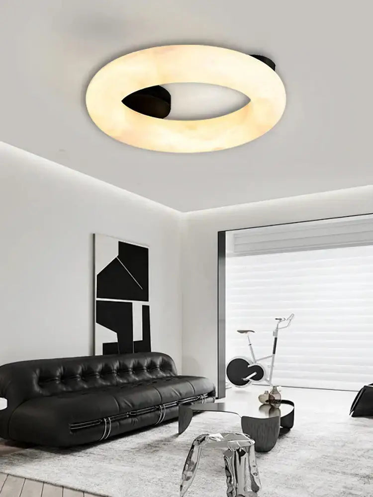 Modern elegant alabaster marble ceiling chandelier with a sleek black inner ring and warm diffused glow for living room