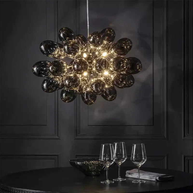 Modern elegant grape glass chandelier with numerous dark glossy orbs forming a spherical dining room pendant light