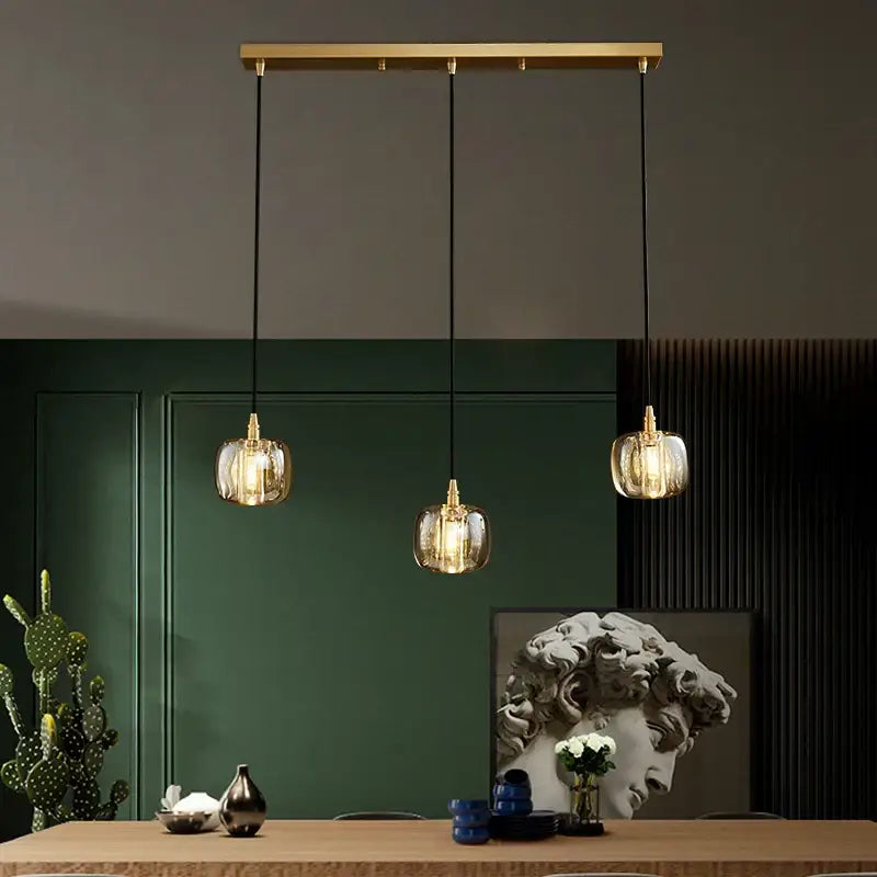 Gold-toned pendant light with clear textured glass shades on brass bar for decorbites elegant rotating staircase decor