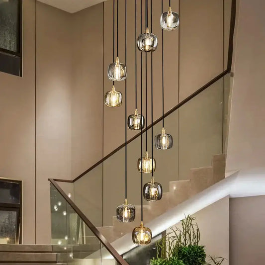 Modern elegant rotating staircase pendant light with multiple spherical glass pendants and gold-toned bases for decorbites elegant rotating decor