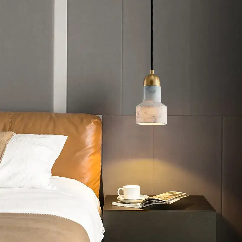 Modern emerald green and brass led pendant lamp with frosted marble shade hanging above bedside table for dining room
