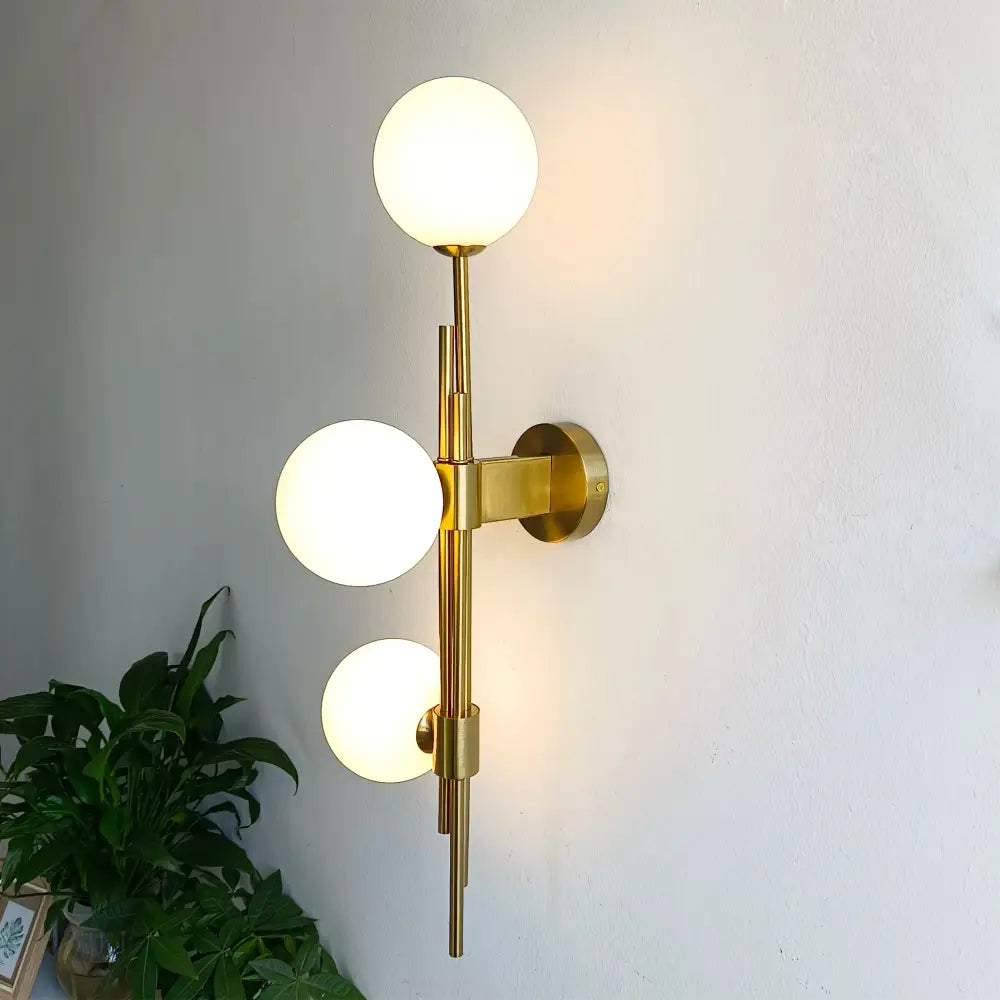 Modern emerald green white glass ball wall lamps with gold-toned wall sconce and three frosted glass globe shades vertical arrangement