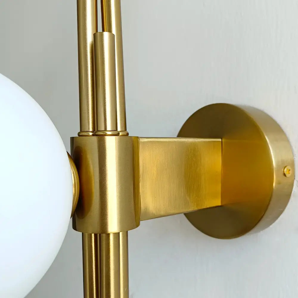 Modern emerald green white glass ball wall lamp with gold-toned brushed metal finish and white spherical glass shade