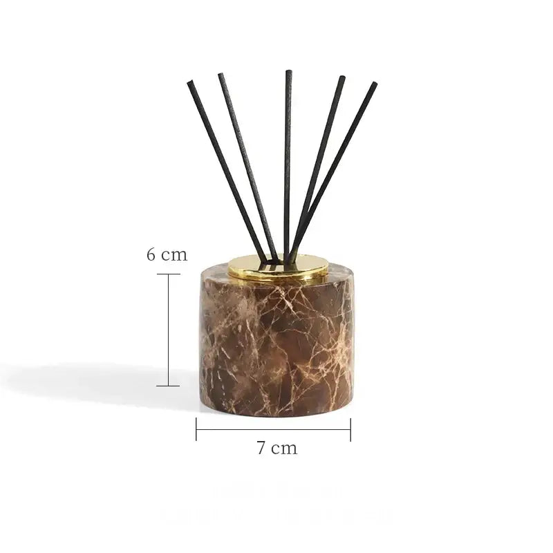 Brown marble reed diffuser with gold-toned metal base and black reeds in modern emperador dark marble bathroom set