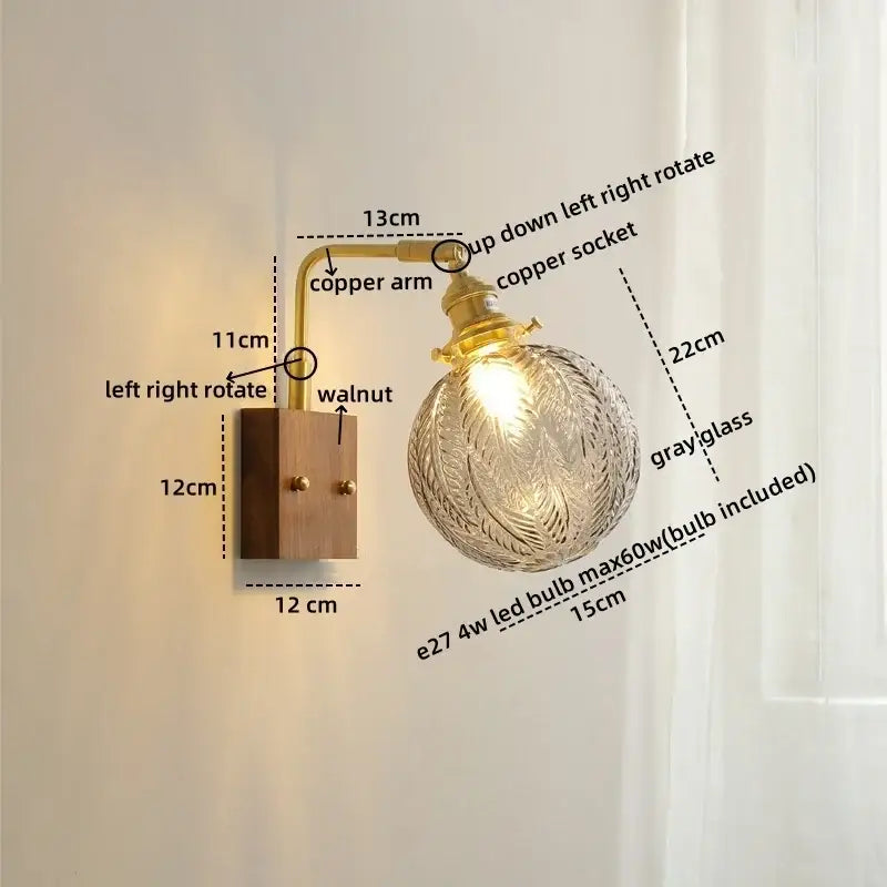 Modern etched glass copper led wall lights featuring a brass copper arm and ornate gray glass globe on walnut wood base